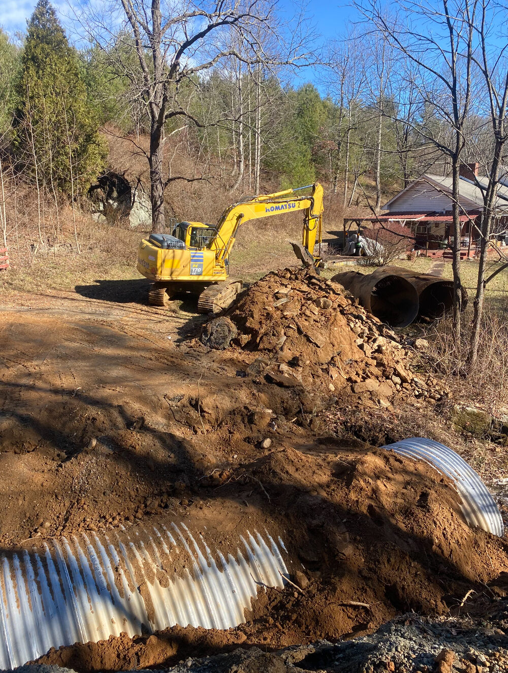 A dozer shaping fresh earth beside a new culvert on a building site