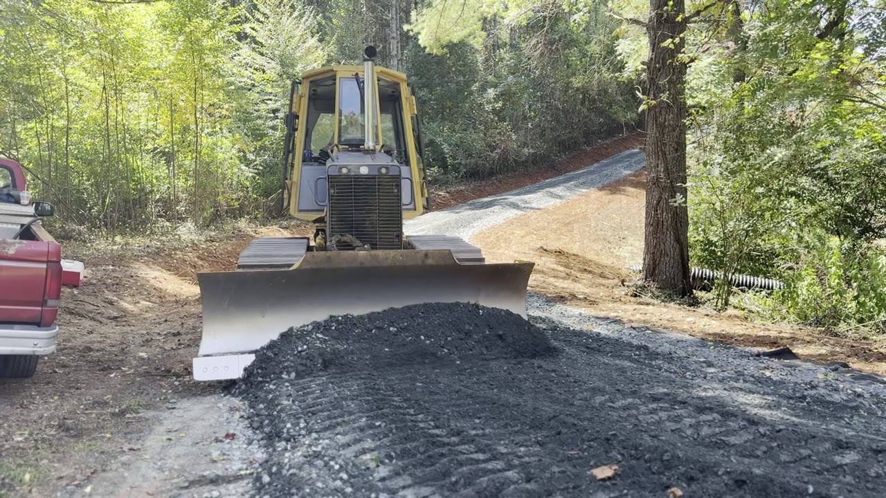 Ethan Tucker's bulldozer grading a fresh gravel driveway through the woods